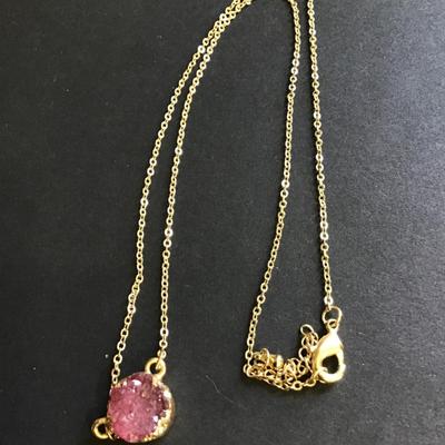 Gold toned necklace with purple crystal