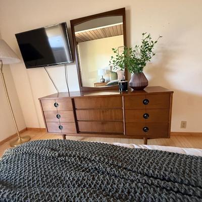 Sale Photo Thumbnail #2: The Stanley dresser is a mid-century modern piece designed for the bedroom. It features a medium wood tone with a walnut finish and chrome handles. Measuring 64 inches in length, 18 inches in width, and 30.5 inches in height, it offers nine drawers for am