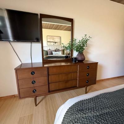 Sale Photo Thumbnail #1: The Stanley dresser is a mid-century modern piece designed for the bedroom. It features a medium wood tone with a walnut finish and chrome handles. Measuring 64 inches in length, 18 inches in width, and 30.5 inches in height, it offers nine drawers for am
