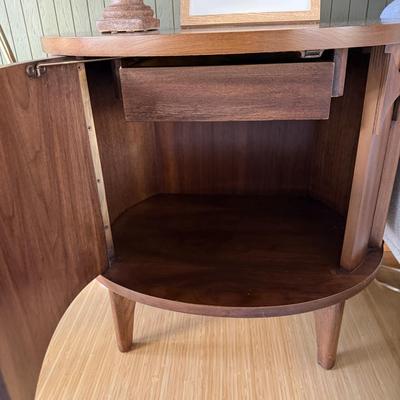 Sale Photo Thumbnail #24: This Kent Coffey nightstand from the Perspecta line is a mid-century modern piece crafted from walnut, featuring a medium wood tone and a single drawer for storage. Measuring 25 inches in height, 25 inches in width, and 17 inches in length, it is fully as