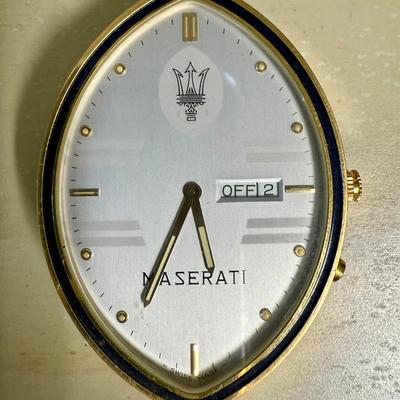 Sale Photo Thumbnail #238: Quartz movement, silvered dial, gilt luminous numeral dots. comes with Maserati boxes (see photos).
Case: gold plated, black lined bezel, vintage dash clock shape, screw secured back, 56 mm x 40 mm, glass crystal
Condition: Looks great, no scratches on cr