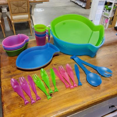 Sale Photo Thumbnail #70: Multicolored, 4 bowls, 4 cups, 4 plates, serving utensils, 3 fork spoon knife sets (missing blue fork and spoon) and carrying case. The back fin of the lid is cracked.