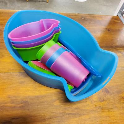 Sale Photo Thumbnail #74: Multicolored, 4 bowls, 4 cups, 4 plates, serving utensils, 3 fork spoon knife sets (missing blue fork and spoon) and carrying case. The back fin of the lid is cracked.