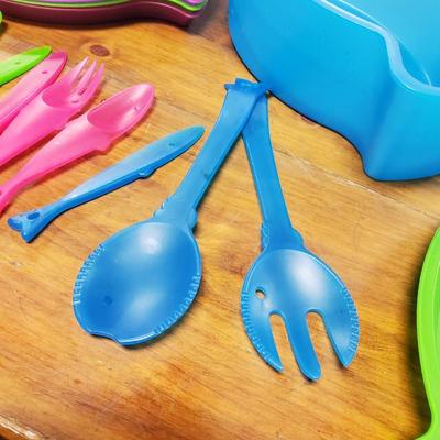 Sale Photo Thumbnail #73: Multicolored, 4 bowls, 4 cups, 4 plates, serving utensils, 3 fork spoon knife sets (missing blue fork and spoon) and carrying case. The back fin of the lid is cracked.