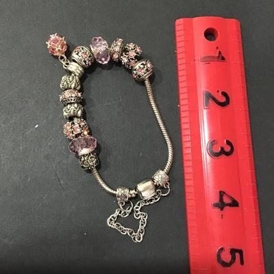 Silver tone bracelet with pink rhinestone charms