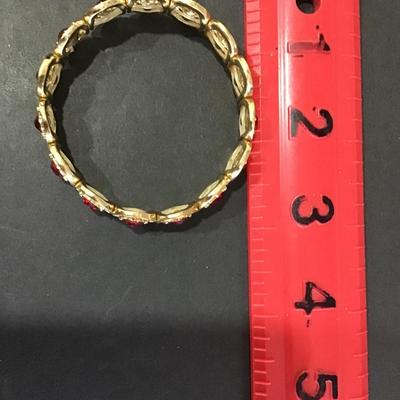 Gold tone, stretch bracelet with red rhinestones