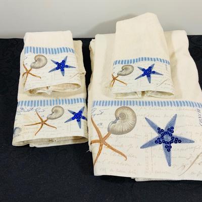 LOT 222: Beach Inspired Decor Featuring Sea Shell Bowls Loaded with Seashells, Towels and Wall Art.