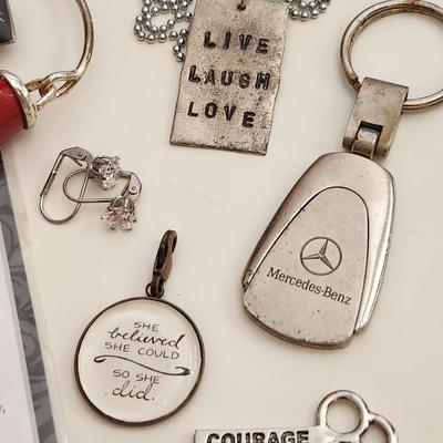 Sale Photo Thumbnail #183: This auction lot is for what is Still in the Jewelry Box.  This gathering offers a pair of Siamese-style earrings, a small token heart, a Mercedes key fob, a Courage Key, a nifty pair of Cubic Zirconia earrings, a stainless steel chain with a slogan penda