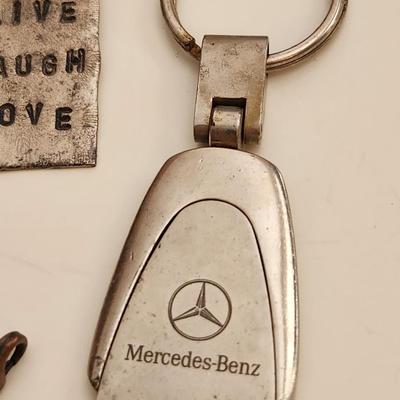 Sale Photo Thumbnail #181: This auction lot is for what is Still in the Jewelry Box.  This gathering offers a pair of Siamese-style earrings, a small token heart, a Mercedes key fob, a Courage Key, a nifty pair of Cubic Zirconia earrings, a stainless steel chain with a slogan penda