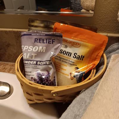 LIGHT TEAL AND TAN BATH TOWELS, EPSON SALT AND A PILLOW FOR SOAKING IN THE TUB