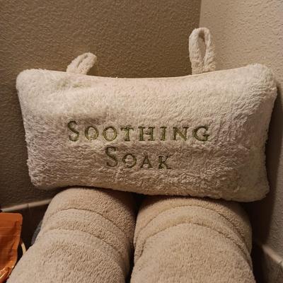 LIGHT TEAL AND TAN BATH TOWELS, EPSON SALT AND A PILLOW FOR SOAKING IN THE TUB