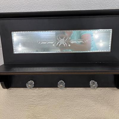 Black shelf, plate rack, dishes, and art