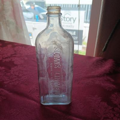 AN ASSORTMENT OF ANTIQUE BOTTLES WITH RAISED LETTERING