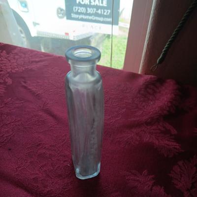 AN ASSORTMENT OF ANTIQUE BOTTLES WITH RAISED LETTERING