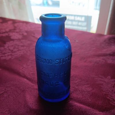 AN ASSORTMENT OF ANTIQUE BOTTLES WITH RAISED LETTERING