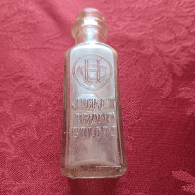 AN ASSORTMENT OF ANTIQUE BOTTLES WITH RAISED LETTERING
