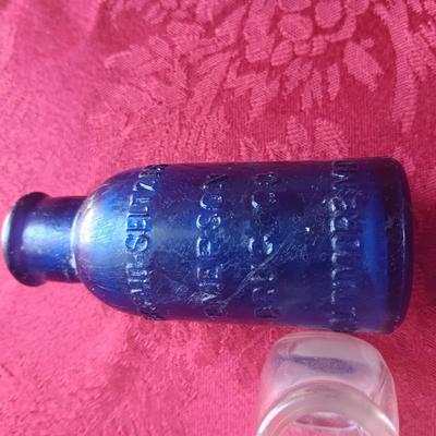 AN ASSORTMENT OF ANTIQUE BOTTLES WITH RAISED LETTERING