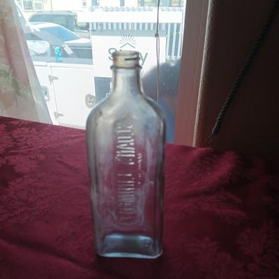 AN ASSORTMENT OF ANTIQUE BOTTLES WITH RAISED LETTERING