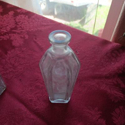 AN ASSORTMENT OF ANTIQUE BOTTLES WITH RAISED LETTERING