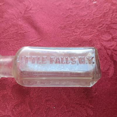 AN ASSORTMENT OF ANTIQUE BOTTLES WITH RAISED LETTERING