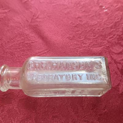 AN ASSORTMENT OF ANTIQUE BOTTLES WITH RAISED LETTERING