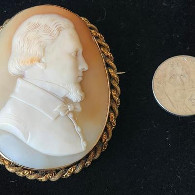 Sale Photo Thumbnail #113: The carving depicts a fine gentleman, perhaps on his Grand Tour, by his attire and hairstyle.  The fine detail 
points to a renowned carver, not identified.  The cameo is set in 14K gold frame, with 10k gold or gold plate braiding.  Victorian or Edwardian