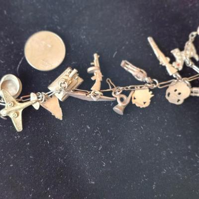 Sale Photo Thumbnail #120: Pewter.  Charms include revolver, Scotty dog, rocket, tank, officers cap, rifle, cannon, wings, bugle, soldier, emblems, rifle, airplane.  
Retails at $100