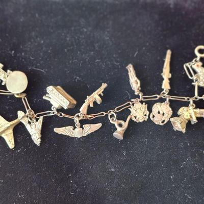 Sale Photo Thumbnail #121: Pewter.  Charms include revolver, Scotty dog, rocket, tank, officers cap, rifle, cannon, wings, bugle, soldier, emblems, rifle, airplane.  
Retails at $100