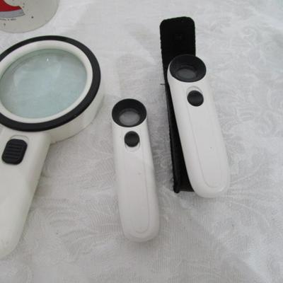 Magnifiers, shoe horns, glasses case, pen, reading glasses, mug, alarm clock