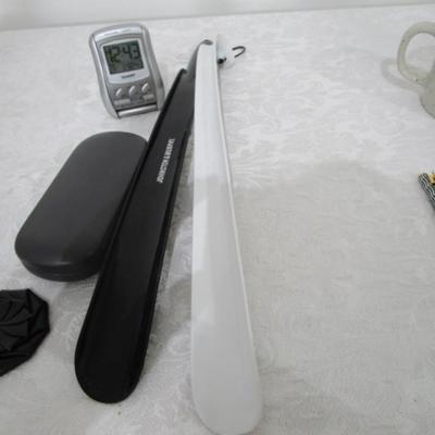 Magnifiers, shoe horns, glasses case, pen, reading glasses, mug, alarm clock