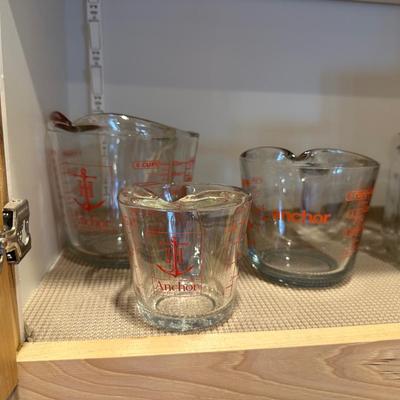 CANNING JARS, MEASURING CUPS AND AN APOTHECARY JAR