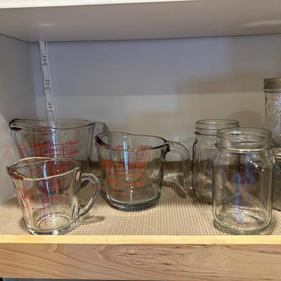 CANNING JARS, MEASURING CUPS AND AN APOTHECARY JAR