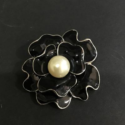Black enamel flower brooch