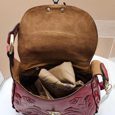 Sale Photo Thumbnail #148: Crossbody, dust bag, one outside pocket, 
tooled berry red, one zippered inside pocket, unique lock closure 
Retail at $169, very nice condition
10 x 7 inches