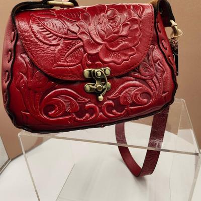Sale Photo Thumbnail #149: Crossbody, dust bag, one outside pocket, 
tooled berry red, one zippered inside pocket, unique lock closure 
Retail at $169, very nice condition
10 x 7 inches