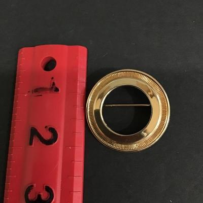 Gold tone circular brooch