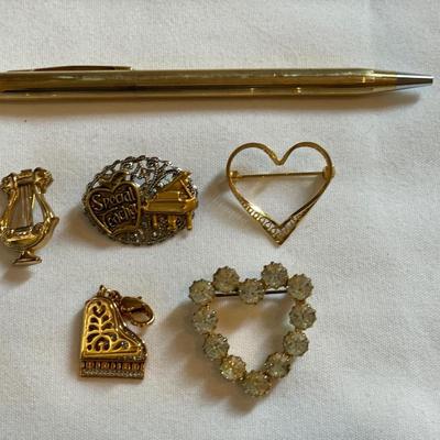 Gold tone charms and pins and Cross pen