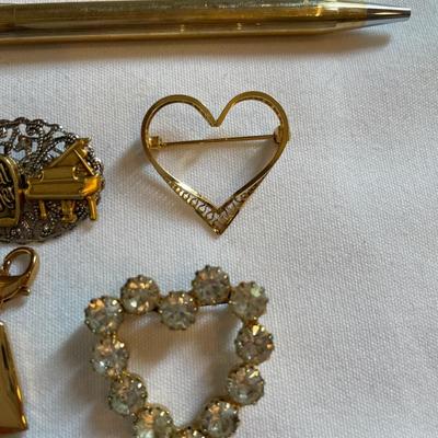 Gold tone charms and pins and Cross pen