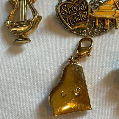 Gold tone charms and pins and Cross pen