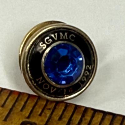Sale Photo Thumbnail #125: Reddish-brown solid wood tie tac and gold-tone 45 Year Service Anniversary Lapel Pin (faux sapphire) from the San Gabriel Valley Medical Center. Both in good condition.