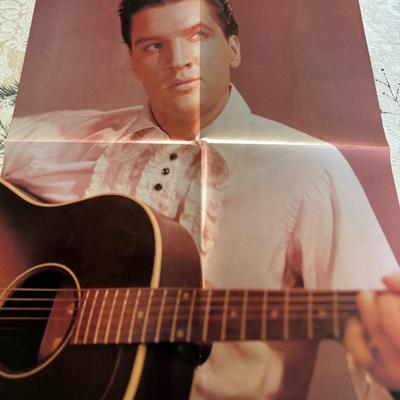 Sale Photo Thumbnail #525: It is described as a vintage, possibly 1970s or 1980s, double-sided poster. One side shows Elvis with a guitar, and the other side (not visible in the image you sent) likely features his daughter, Lisa Marie Presley.