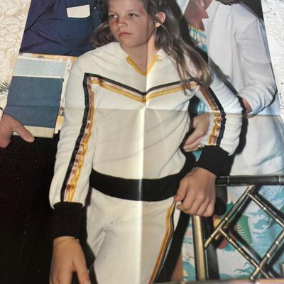 Sale Photo Thumbnail #526: It is described as a vintage, possibly 1970s or 1980s, double-sided poster. One side shows Elvis with a guitar, and the other side (not visible in the image you sent) likely features his daughter, Lisa Marie Presley.