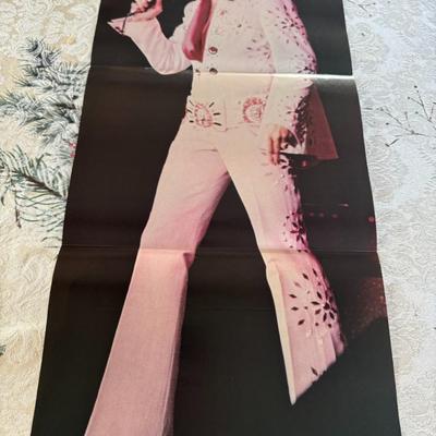 Sale Photo Thumbnail #520: The image shows a poster of Elvis Presley in his iconic white jumpsuit, singing on stage.
vintage 1976 poster that measures 23" x 35.5".