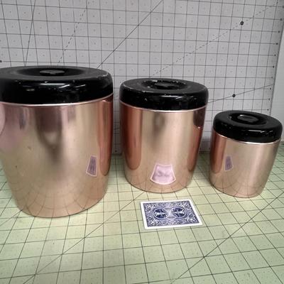 Sale Photo Thumbnail #91: Set of 3 copper-tone canister with glossy black plastic lids.