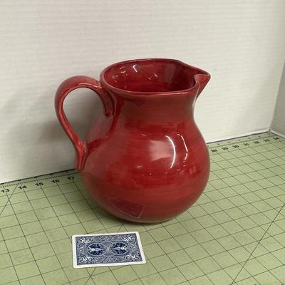 Sale Photo Thumbnail #395: Red ceramic pitcher with classic round-bellied shape.