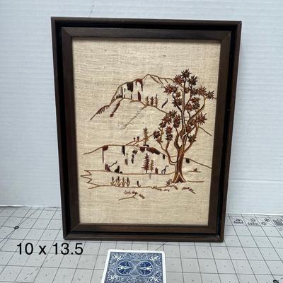 Sale Photo Thumbnail #752: Hand-stitched landscape scene, wooden frame, rustic decor, natural tones.