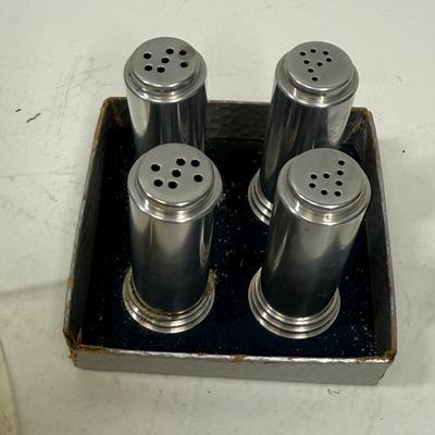 Sale Photo Thumbnail #505: Set of 4 (2 pair) in original packaging.  Salt shakers have some external discoloration, most likely because they both contained salt.  They can likely be cleaned and polished to return them to their original look. Approx. 2" tall.