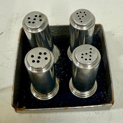 Sale Photo Thumbnail #503: Set of 4 (2 pair) in original packaging.  Salt shakers have some external discoloration, most likely because they both contained salt.  They can likely be cleaned and polished to return them to their original look. Approx. 2" tall.