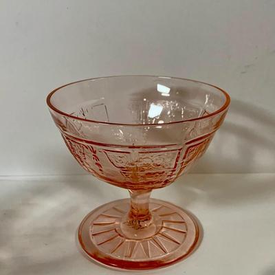 LOT 69: Large Selection of Pink Depression Glass Including Raised Platters, Covered Bowl, Candy Dish with Lid, Stemmed Glassed and Tooth...