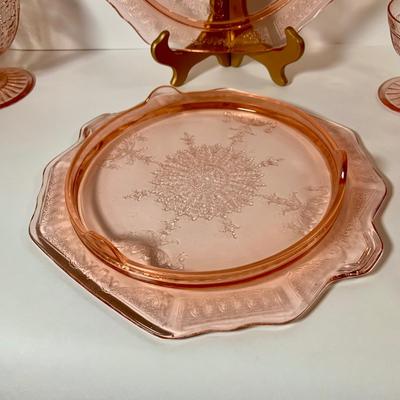 LOT 69: Large Selection of Pink Depression Glass Including Raised Platters, Covered Bowl, Candy Dish with Lid, Stemmed Glassed and Tooth...